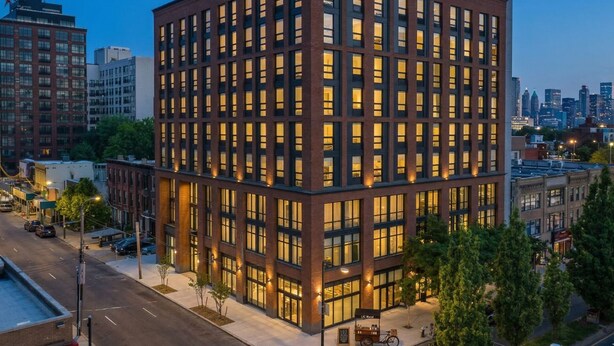 A modern multi-story building with a grid of windows, surrounded by other buildings and a street. - Court Square Hotel Long Island City New York , Belvilla District 6 Formerly Sonder (Long Island City)