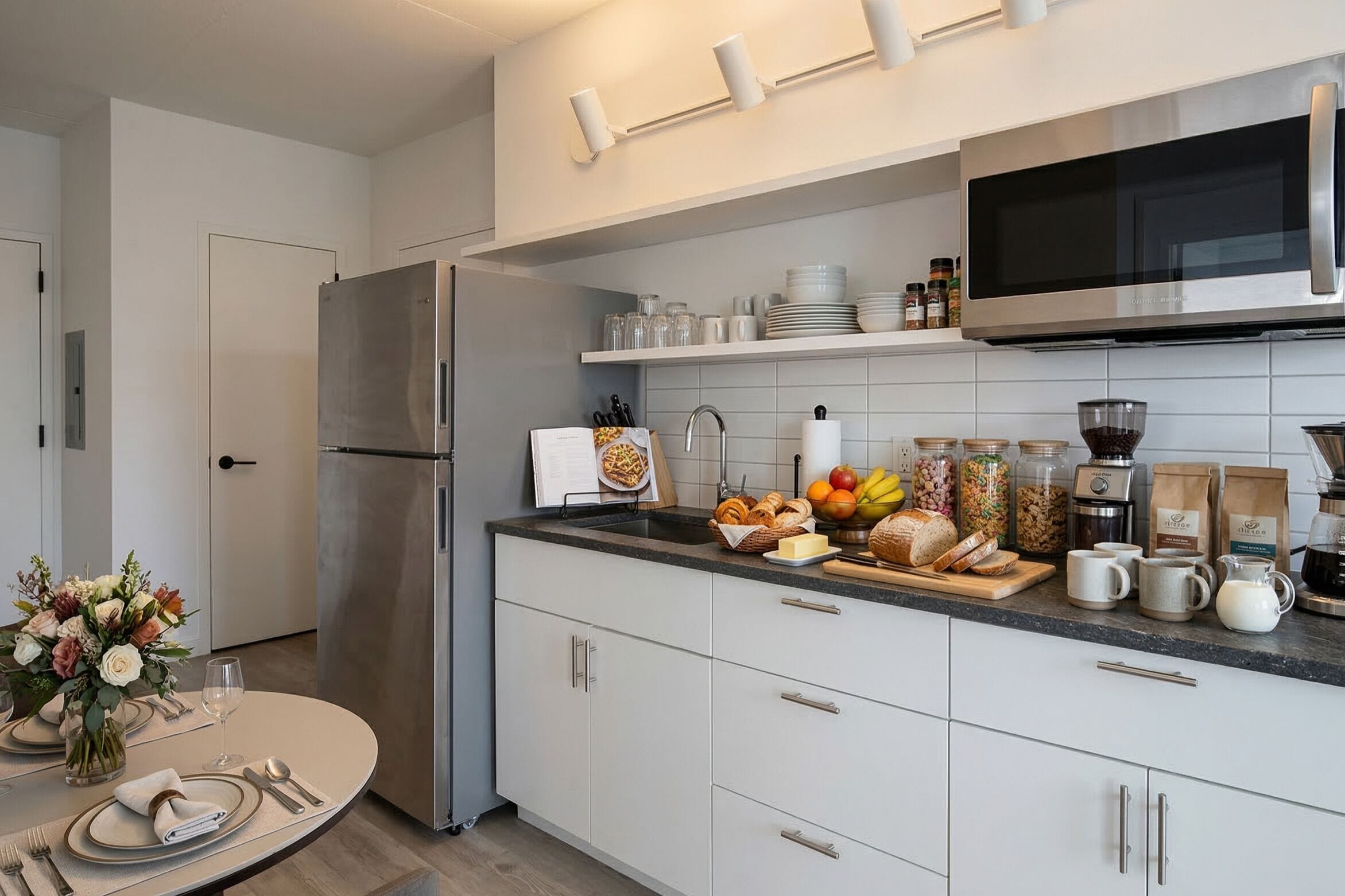 Une cuisine moderne équipée d’un réfrigérateur en acier inoxydable, d’un four à micro-ondes et d’une variété d’aliments disposés sur le plan de travail.