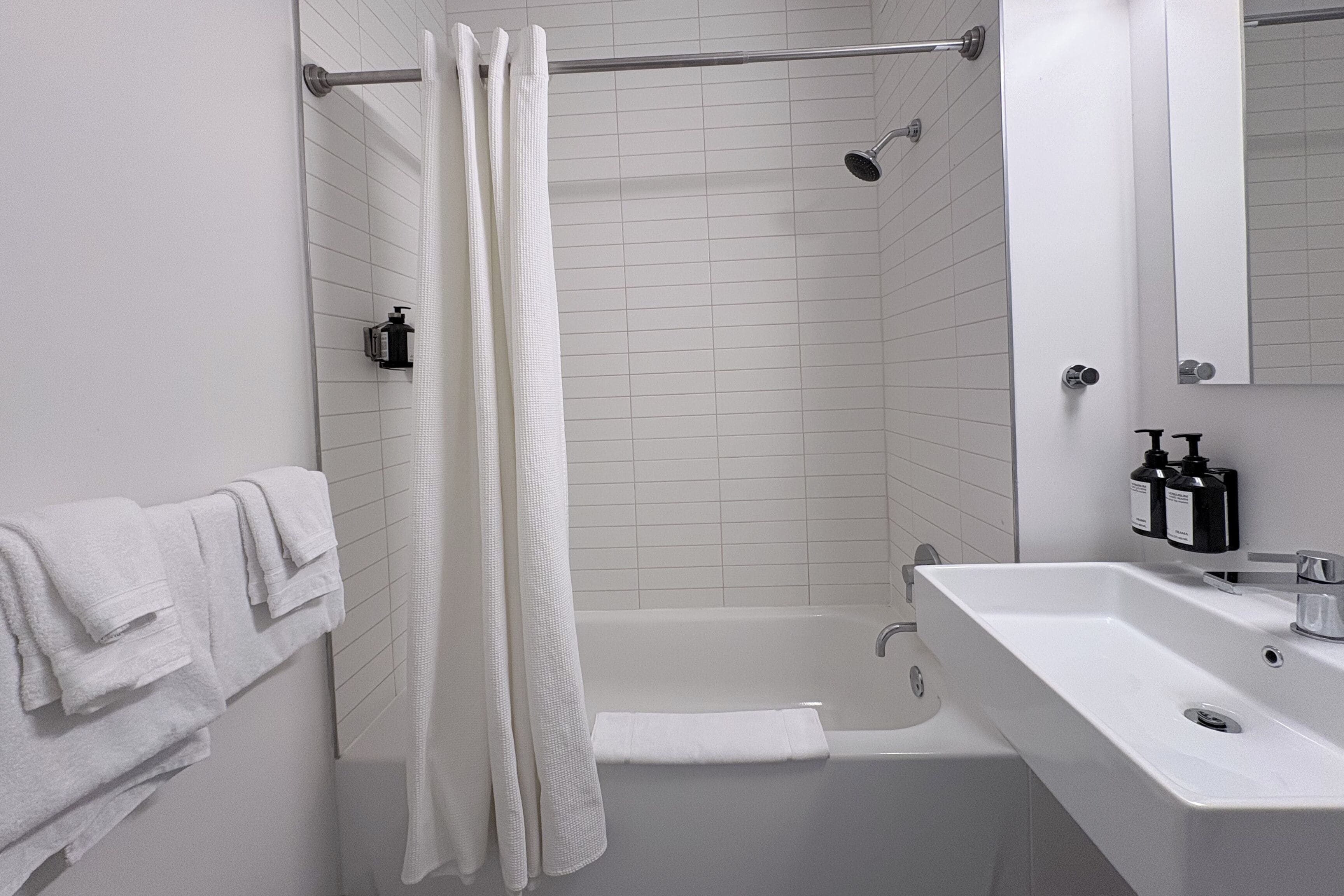 A modern bathroom with a bathtub, a shower, and a sink.