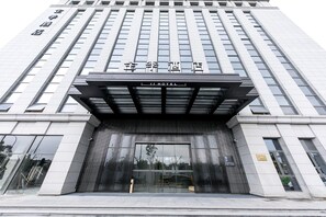A modern hotel entrance with a prominent sign and a covered entrance area. - Ji Hotel (Hangzhou)