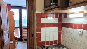 Keittiössä on puukaapit, mikroaaltouuni, leivänpaahdin ja pesuallas.