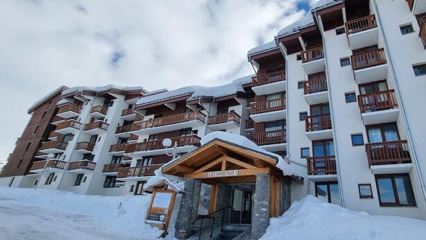 Un hotel a più piani con balconi e un cartello con la scritta "LES HAMEAUX 1".
