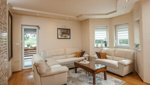 Un salon moderne avec un canapé d’angle beige, une table basse en bois et un tapis à motifs.