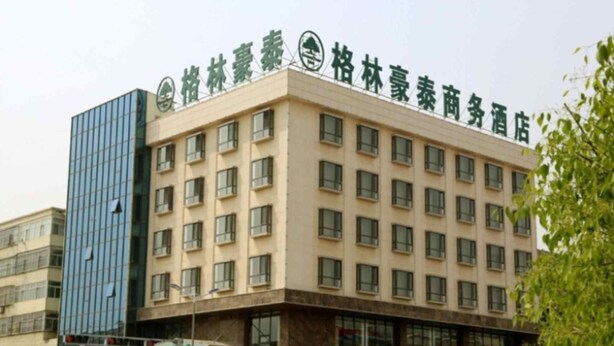 A multi-story hotel with a modern facade, featuring a mix of glass and brickwork. - Greentree Inn Jiangsu Wuxi New District Shengang World Express Hotel (Wuxi)