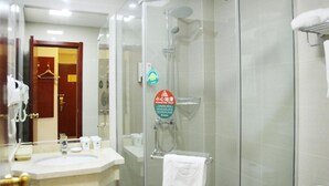 A hotel bathroom with a glass-enclosed shower, a sink with toiletries, and a towel rack. - Greentree Inn Jiangsu Wuxi New District Shengang World Express Hotel (Wuxi)