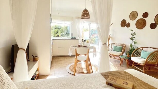 Een ruime slaapkamer met een groot bed, een zithoek en uitzicht op de omgeving.