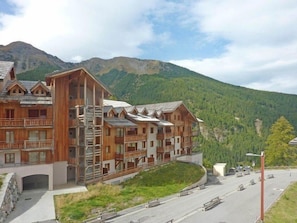 A wooden lodge with multiple balconies and a ski lift in the background. - Ski-in/ski-out & foot of the slopes, 3rd floor, swimming pool, sauna, balcony, tv, ski locker, 61m² (Les Orres)