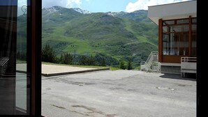 Vue depuis une pièce dotée d’une grande fenêtre donnant sur un paysage montagneux.