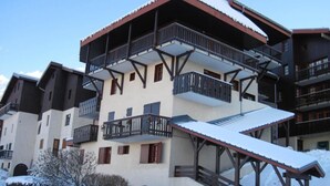 Un immeuble à plusieurs étages, doté de balcons et d’un escalier extérieur abrité.