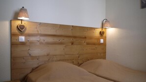 A wooden headboard with two wall-mounted lamps and a heart-shaped drawer. - 300m from resort center, 3rd floor, view mountain, balcony, 27m², Méribel-Mottaret (Méribel - Les Allues)