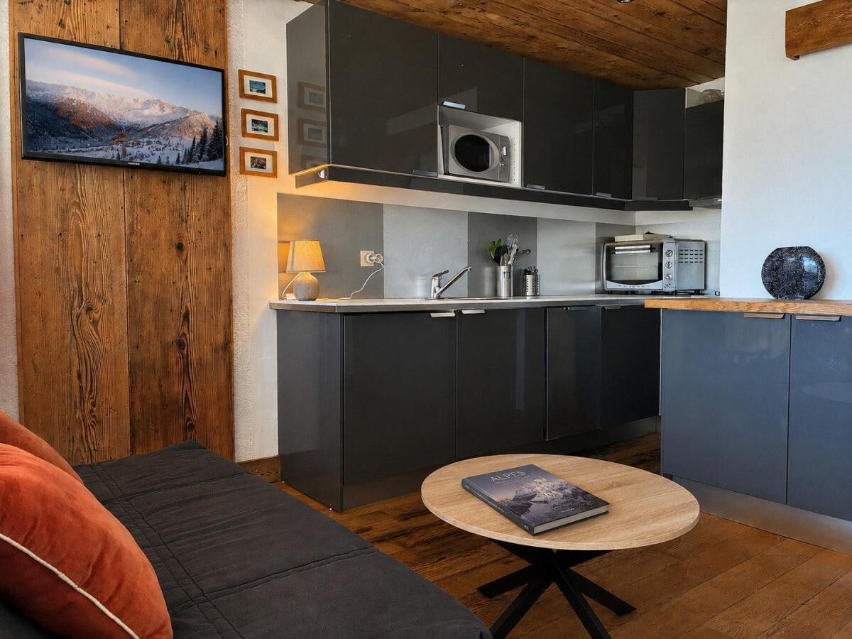 A modern kitchen with dark cabinets, a microwave, and a built-in oven.