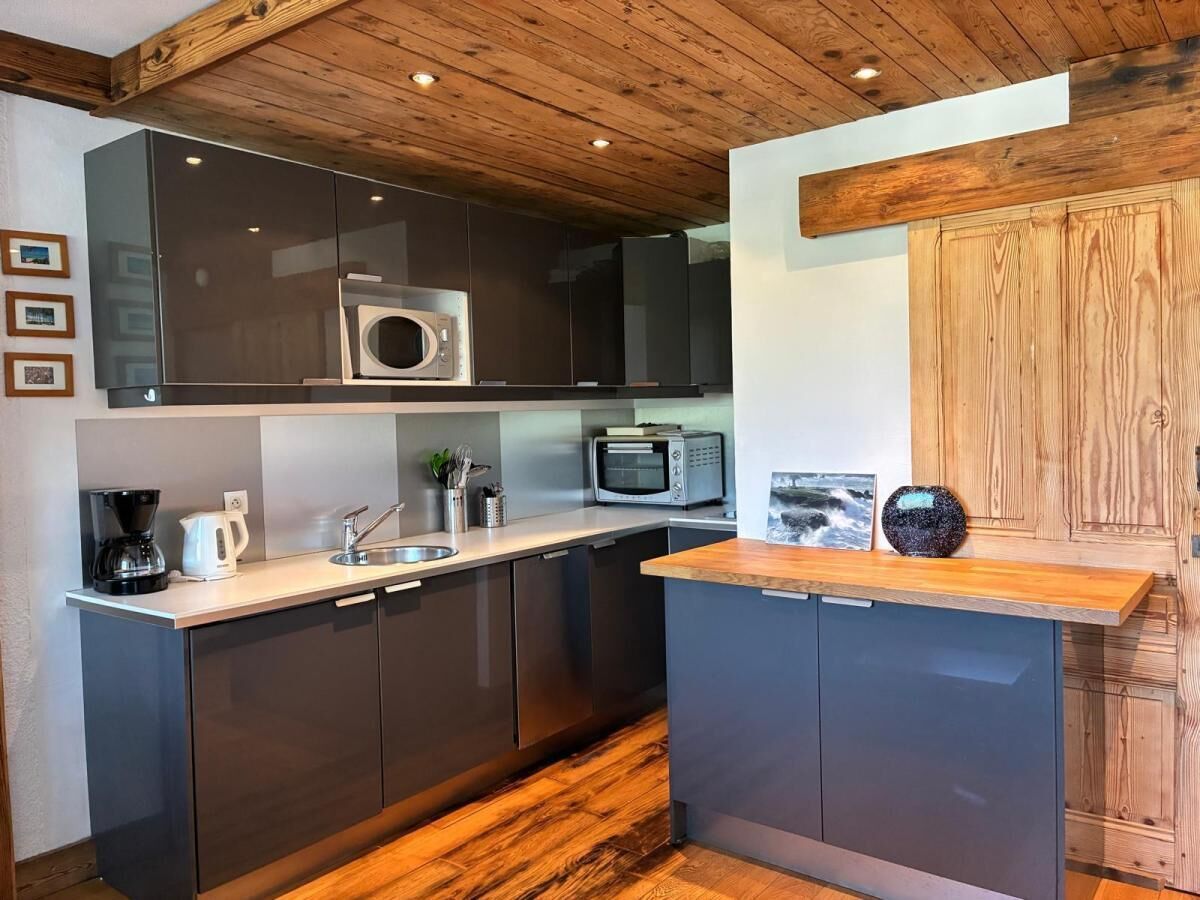 A modern kitchen with dark cabinets, a microwave, a toaster, and a coffee maker.