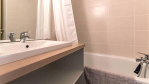 A bathroom with a white sink, mirror, and bathtub. - 50m from ski slopes, 5th floor, balcony, tv, 28m², Montchavin La Plagne (Bellentre)