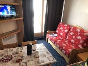 Relax in this inviting room with a sofa, television, and dining table.