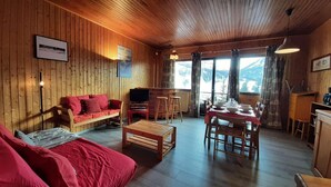 A wooden cabin interior with a sofa, TV, dining table, and chairs. - 1st floor, view mountain, tv, 50m², Montgenèvre (Montgenèvre)