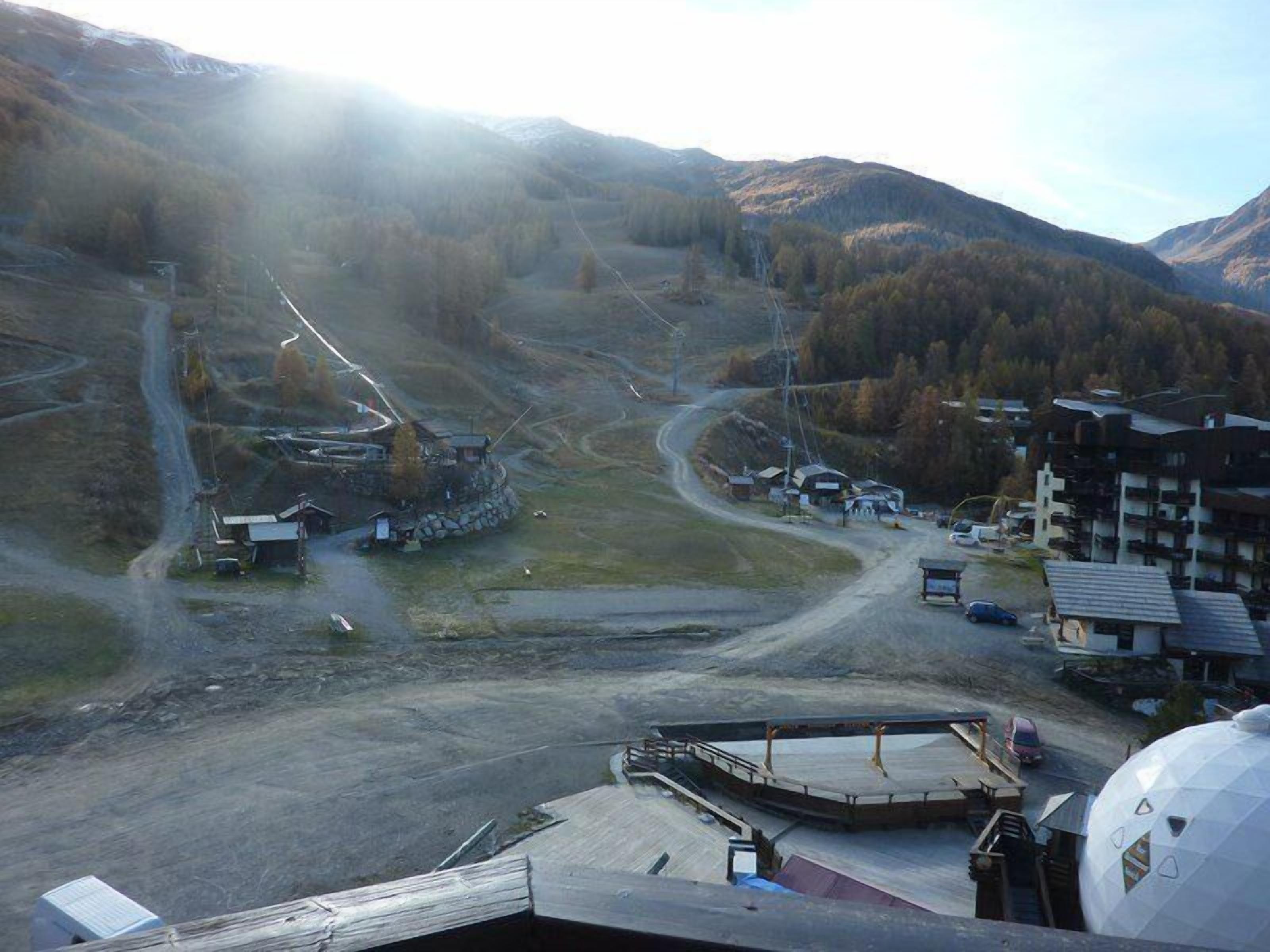 Een skigebied met een stoeltjeslift, gebouwen en een bergachtig landschap.