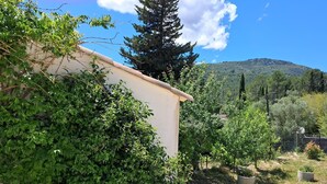A building surrounded by dense greenery and a mountainous backdrop. - Villa Pampérigouste - air conditioning and swimming pool (SOLLIES TOUCAS)