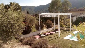 A garden with a pergola, outdoor seating, and a pool. - Villa Pampérigouste - air conditioning and swimming pool (SOLLIES TOUCAS)