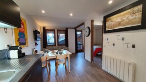 Une cuisine moderne dotée d’un îlot central, de planchers en bois et d’un coin repas avec des chaises.