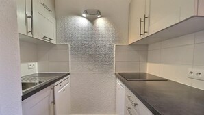 A compact kitchen with white cabinets, a stainless steel sink, and a black countertop. - 10m from ski slopes, 3rd floor, balcony, 43m², Méribel-Mottaret (Méribel - Les Allues)