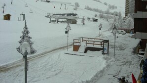 A snow-covered ski slope with a small wooden shelter and a chairlift in the background. - 10m from ski slopes, 1st floor, view valley, swimming pool, tv, ski locker, 24m², Le Corbier (Le Corbier)