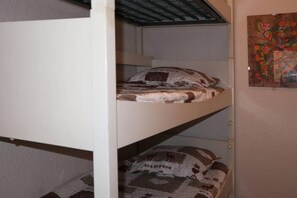 A bunk bed with a patterned bedspread and pillows.