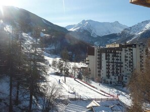 A snow-covered mountain landscape with a multi-story building in the foreground.