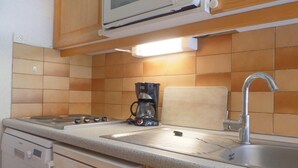 A kitchen with a microwave, coffee maker, sink, and dishwasher. - 10m from ski slopes, 33m², Méribel-Mottaret (Méribel - Les Allues)
