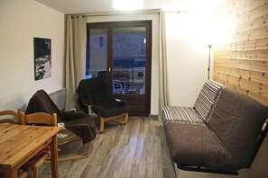 A small living area with a sofa, a chair, a table, and a view through a glass door. - Ski-in/ski-out & foot of the slopes, 7th floor, view valley, balcony, tv, 26m², Les Orres (Les Orres)