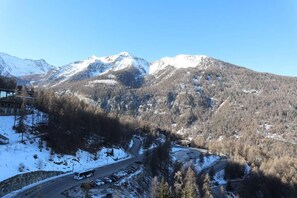 Un paysage montagneux avec une route, un autobus et des voitures garées.