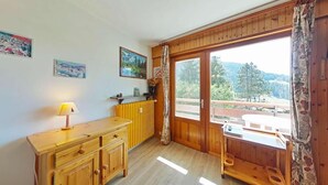 Eine gemütliche Küche mit Holzschränken, einer Arbeitsplatte und einem Fenster mit Blick auf Bäume.