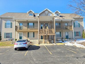 A multi-story building with a covered entrance and a car parked in the driveway. - Romantic Getaway Walk-in Suite. Resort Amenities! Remodeled! Excellent Rates! (Branson)