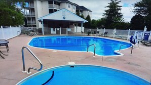 Une piscine dotée d’un espace couvert et de chaises longues.
