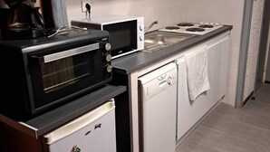 Een compacte keuken met een inbouwoven, magnetron en vaatwasser.