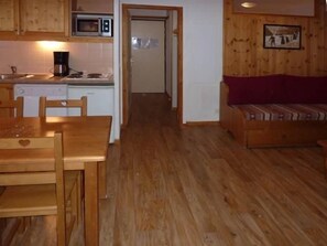 A wooden-floored kitchen with a microwave, a coffee maker, and a dishwasher.