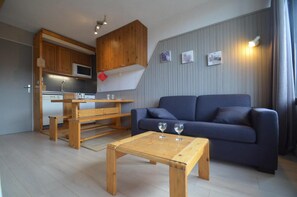 A compact living space with a kitchenette, a dining area, and a seating area with a sofa and coffee table. - 150m from shops, 2nd floor, view mountain, balcony, tv, ski locker, 26m², Les Menuires (Les Menuires)
