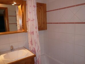 A bathroom with a wooden vanity, a white sink, and a shower curtain. - 1st floor, view village, terrace, tv, ski locker, 39m², Méribel (Les Allues)