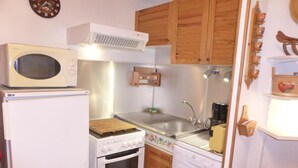 A compact kitchen with a microwave, stove, oven, and dishwasher.