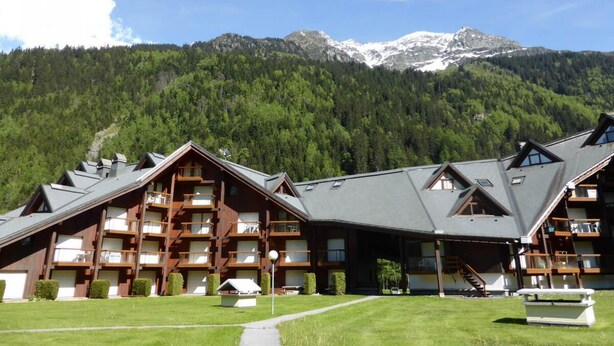 A lodge with multiple balconies and a mountain backdrop.