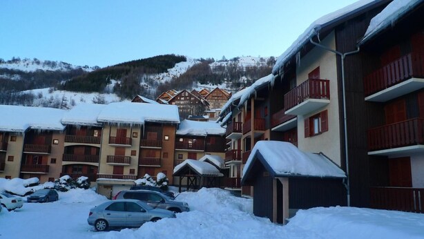 A snow-covered hotel with multiple balconies and a parking area. - 200m from shops, Ground floor, balcony, tv, ski locker, 29m², Valloire (Valloire)