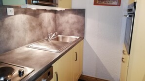 A compact kitchen with a sink, stove, and cabinets. - 26m from ski slopes, 4th floor, balcony, tv, ski locker, 35m², Valmorel (Valmorel)