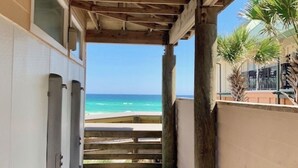 A covered walkway leading to a beach with a wooden ceiling and a view of the ocean. - Boho Beach Vibes @ Caribbean Dunes,125 (Destin)