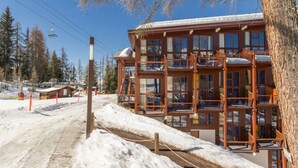 A wooden multi-story building with balconies, a ski lift in the background, and a snowy landscape. - 300m from resort center, 1st floor, view valley, balcony, tv, 37m², Les Arcs (Les Arcs)
