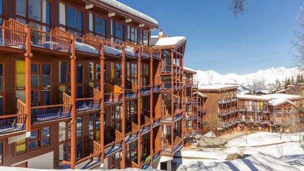 A multi-story hotel with balconies, large windows, and a snowy mountain backdrop. - 300m from resort center, 1st floor, view valley, balcony, tv, 37m², Les Arcs (Les Arcs)