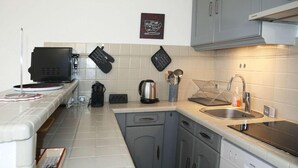 A compact kitchen with grey cabinets, a built-in oven, a coffee machine, and a kettle. - 15m from ski slopes, 6th floor, balcony, 23m², Les Orres (Les Orres)