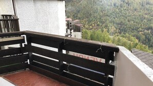A balcony with a black metal railing overlooking a forested valley. - 15m from ski slopes, 6th floor, balcony, 23m², Les Orres (Les Orres)