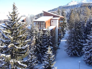 A modern building surrounded by snow-covered trees, likely a lodge or resort. - 200m from resort center, 2nd floor, tv, 30m², Les Arcs (Les Arcs)