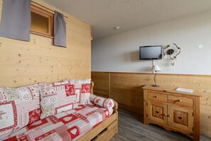 Relax in comfort with a sofa, flat-screen TV, and a convenient cabinet.