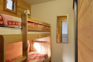 Cozy corner accommodation with bunk beds and a window offering a view of the outdoors.