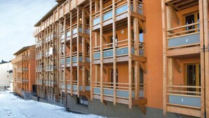A multi-story building with wooden balconies and large windows, likely a hotel or resort. - 30m from resort center, swimming pool, sauna, hammam, terrace, balcony, tv, ski locker, 66m² (Font-Romeu-Odeillo-Via)